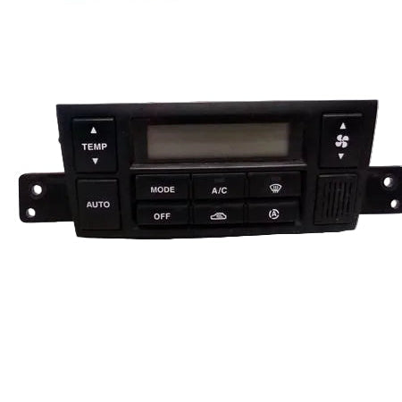 Car climate control panel on a white surface with Conrad's Auto Salvage sign in the background.